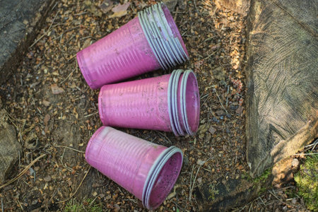Close up of pink plastic cups on the ground in the forest.の写真素材
