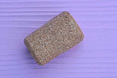 one brown cork stopper lies on a wooden pink tableの写真素材