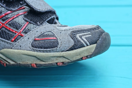 toe of one colored sneaker on blue tableの写真素材