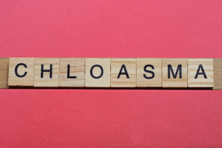 ext the word chloasma from gray wooden small letters with black font on an red tableの写真素材