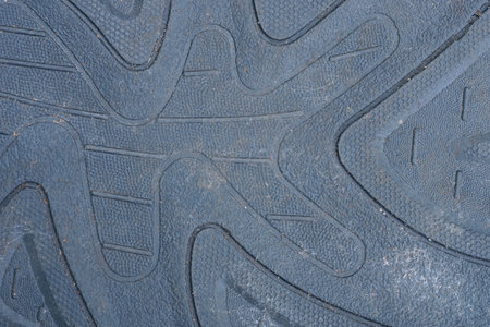 gray black background of a piece of old dirty plastic sole with a patternの写真素材