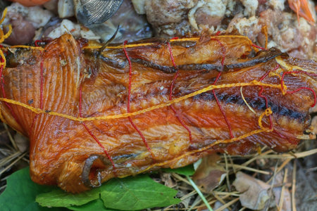 one big piece of red smoked fish lies on the ground on the streetの写真素材