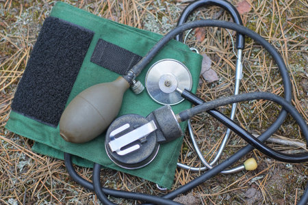 a set of medical instruments from a blood pressure monitor and a stethoscope with a tonometer lie on...
