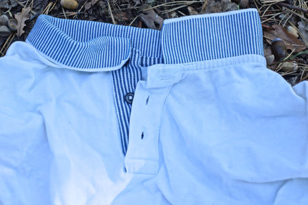 blue collar on white wrinkled fabric of t-shirt clothes lies on ground on summer streetの写真素材