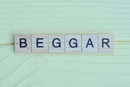 the gray word of gray small wooden letters lie on a yellow tableの写真素材