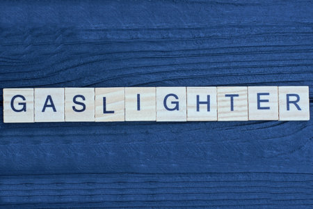 text on word gaslighter from gray wooden letters on a black backgroundの写真素材