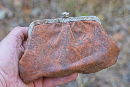 hand holding one big old brown leather wallet