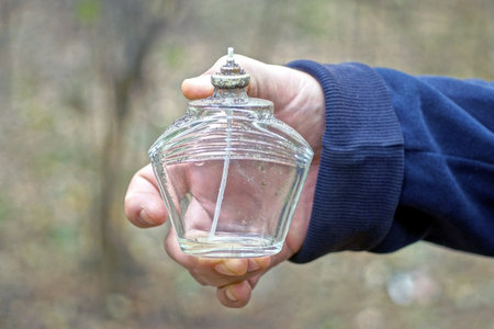 hand holds one empty small white transparent glass bottle in the streetの写真素材