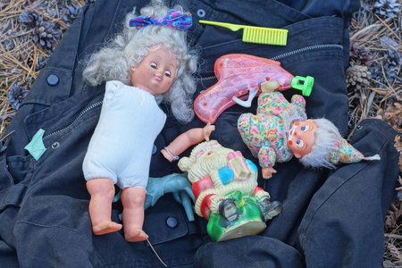 set of colorful toys lie on black cloth on the ground on a summer streetの写真素材