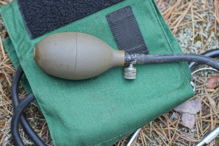 Sphygmomanometer lying on a green cloth in the forest