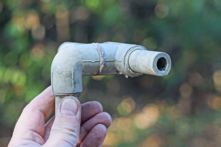Old pipe in hand on the background of the forest.