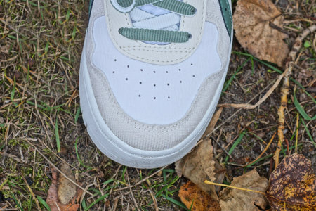 White sneakers on the grass in autumn. Close-up shot.
