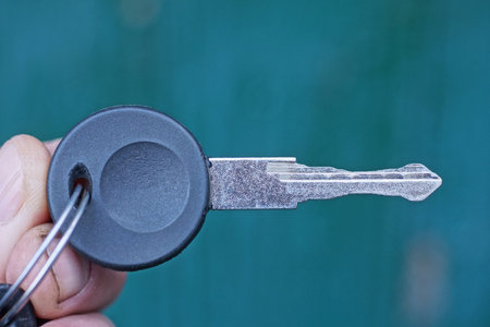 hand holding one old car key on green backgroundの写真素材