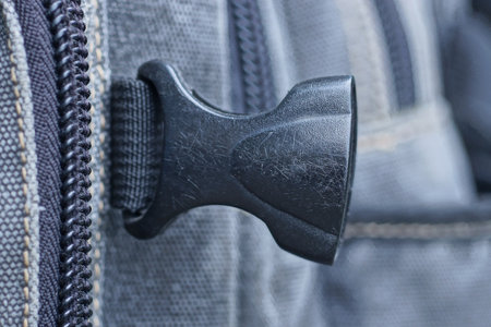 one black closed plastic carabiner snap on gray backpack strapの写真素材