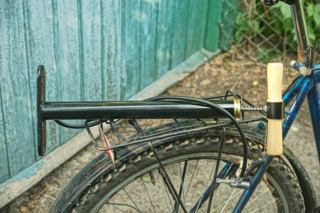 one black pump with hose lies on the bike rack on a summer streetの写真素材