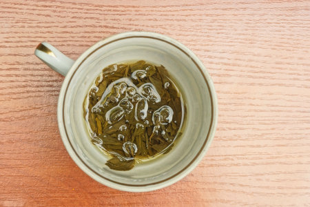 one cup full of green tea drink stands on the brown tableの写真素材