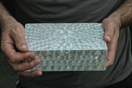 man in gray clothes holds one big closed white box in his handsの写真素材