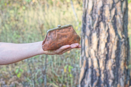 hand holding one big old brown leather wallet