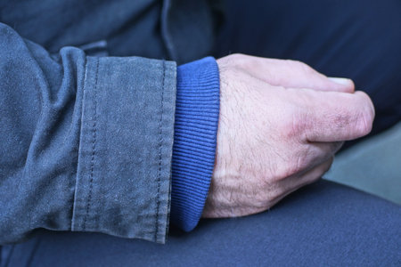part one hand in blue sleeve sweater and gray black jacket in the streetの写真素材