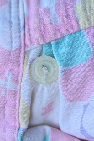 one gray button on colored fabric clothing with pocket