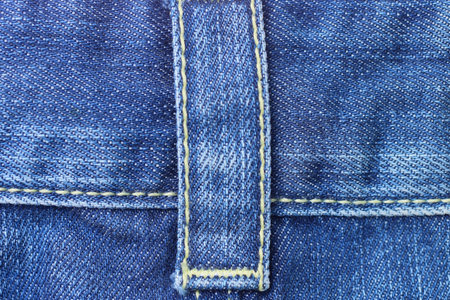 part of cotton blue frayed trousers made of fabric with seams with a harness