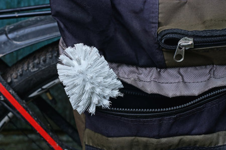 A single white plastic toilet brush lies in the pocket of a gray bagの写真素材