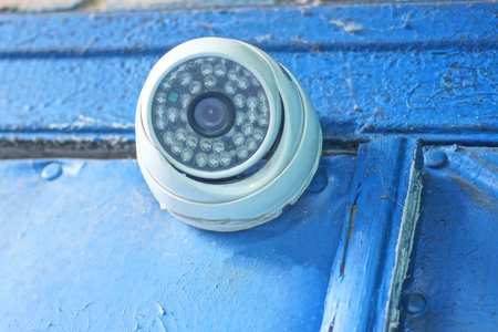 One white webcam on a blue wall