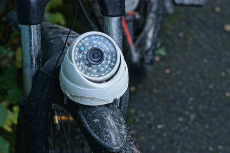 A single white camera stands on a black bicycle fender on a summer streetの写真素材