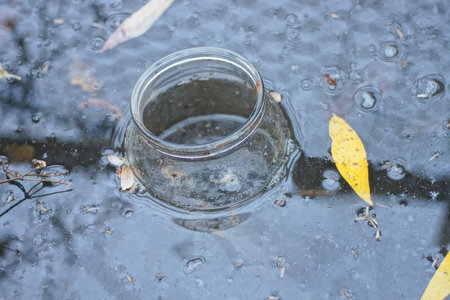 One dirty empty glass jar floats in the water of a lakeの写真素材
