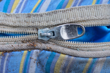 old single gray metal zip on white and colored dirty bag fabricの写真素材