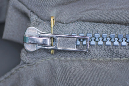 one closed metallic zip on gray synthetic clothing fabric