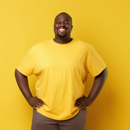 Fat african american man smiling in yellow t-shirt on yellow background isolated AIの素材
