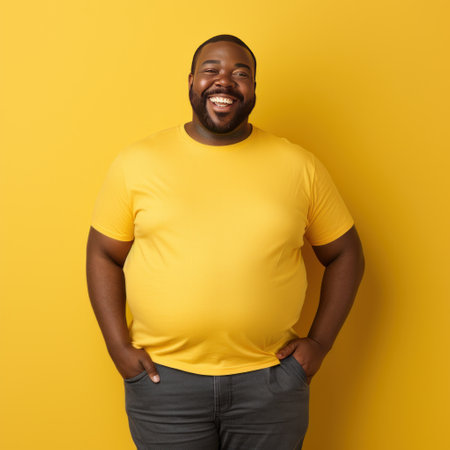 Fat man smiling in yellow t-shirt on yellow background isolated AIの素材
