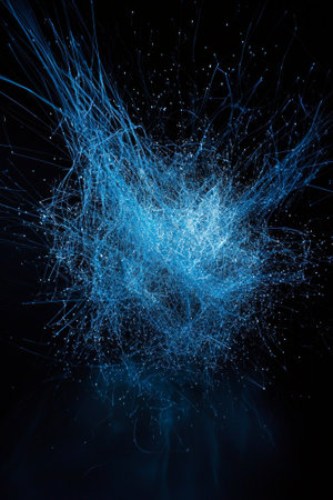 An energetic explosion of blue particles radiates outward against a black background, creating a mesmerizing display of cosmic energy and vibrant motion.の素材
