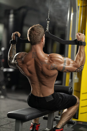 In a fitness center an athlete engages in a front pulldown exercise showcasing impressive upper body...