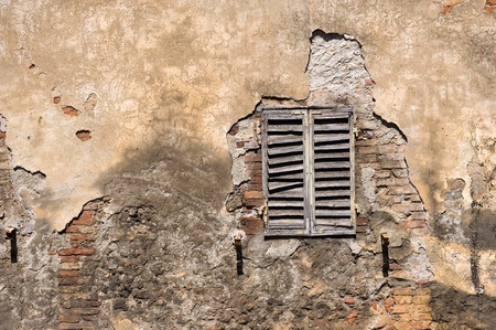 A part of an old wall with window of a house in Tuscany in Italy.の写真素材