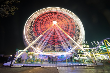 A turning ferris wheel in the evening at an amusement park