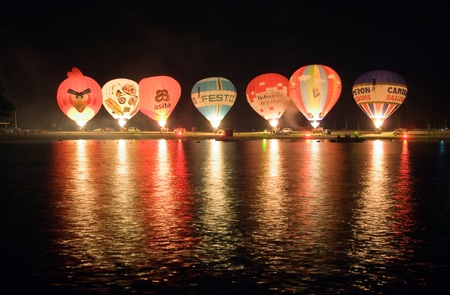 OLDENZAAL, THE NETHERLANDS - AUGUST 23  Seven hot air balloons are glowing on the beach of a recreation pond, at a 4 days festival in the Netherlands, Aug 23, 2013 のeditorial素材