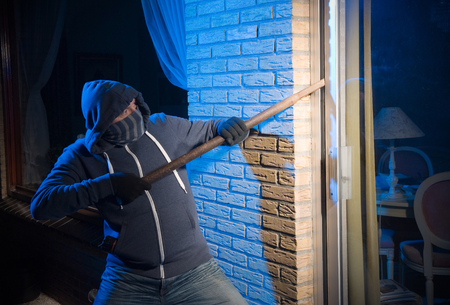 A burglar is opening the backdoor of a houseの写真素材