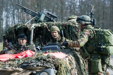 GEESTEREN, NETHERLANDS - MARCH 25  Three camouflaged soldiers are waiting for instructions during a...
