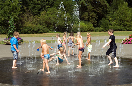 ENSCHEDE, NETHERLANDS - JUNE 06  Children are playing with water from a fountain in a park on the first hot day of the summer, June 06, 2013 in the Netherlandsのeditorial素材