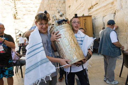 JERUSALEM, ISRAEL - OCT 06, 2014: Two 13 years old boys are carrying a torah scroll during a Bar Mitzvah ritual at the Wailing wall in Jerusalem.のeditorial素材
