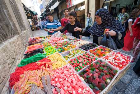JERUSALEM, ISRAEL - OCTOBER 07, 2014: Woman are watching and buying sweets at a candy store in one of the small streets in the old city of Jerusalemのeditorial素材
