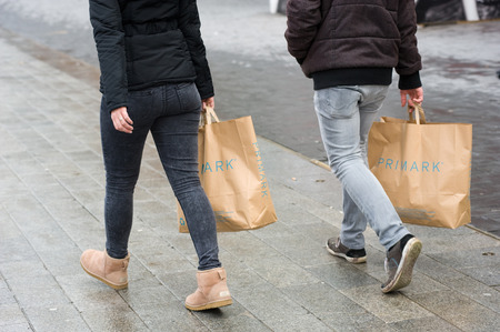 ENSCHEDE, THE NETHERLANDS - 05 FEB, 2015: Twp persons with shopping bags from Primark warehouse are walking on the streetのeditorial素材