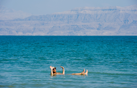 DEAD SEA, ISRAEL - OCT 13, 2014: A man is floating in the water of the dead sea in Israelのeditorial素材