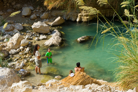 EIN GEDI, ISRAEL - OCT 15, 2014: A family is relaxing in the water of the oasis Ein Gedi close to the dead sea in Israelのeditorial素材
