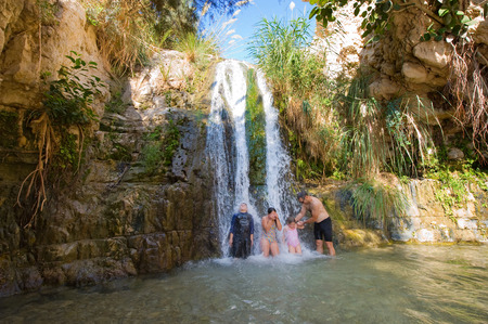 EIN GEDI, ISRAEL - OCT 15, 2014: Children and a man are playing in one of the waterfalls of the oasis Ein Gedi close to the dead sea in Israelのeditorial素材