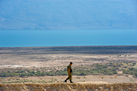 DEAD SEA, ISRAEL - OCT 15, 2014: Israelien soldier walking alone on a hill in front of the dead sea in Israel close to Qumranのeditorial素材