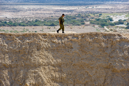 DEAD SEA, ISRAEL - OCT 15, 2014: Israelien soldier walking alone on a hill in front of the dead sea in Israel close to Qumranのeditorial素材