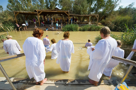 YERICHO, ISRAEL - OCT 15, 2014: Religious christians with white clothes going into the water of the Jordan river at baptismal site Qasr el Yahud near Yerichoのeditorial素材
